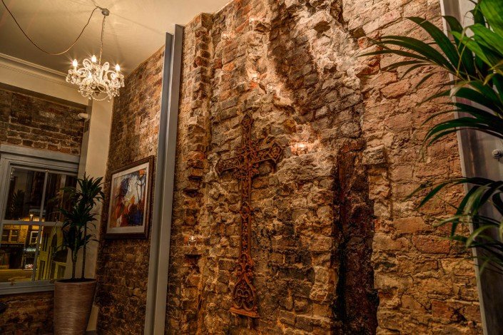 Exposed brickwork and salvaged cross at El Gato Negro Manchester